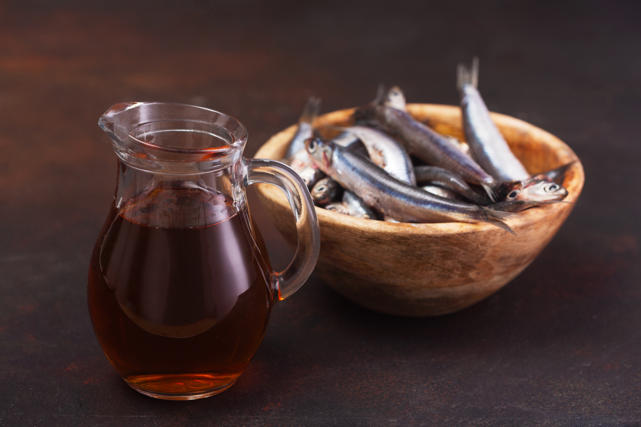 Garum fish sauce made from anchovies on the dark background